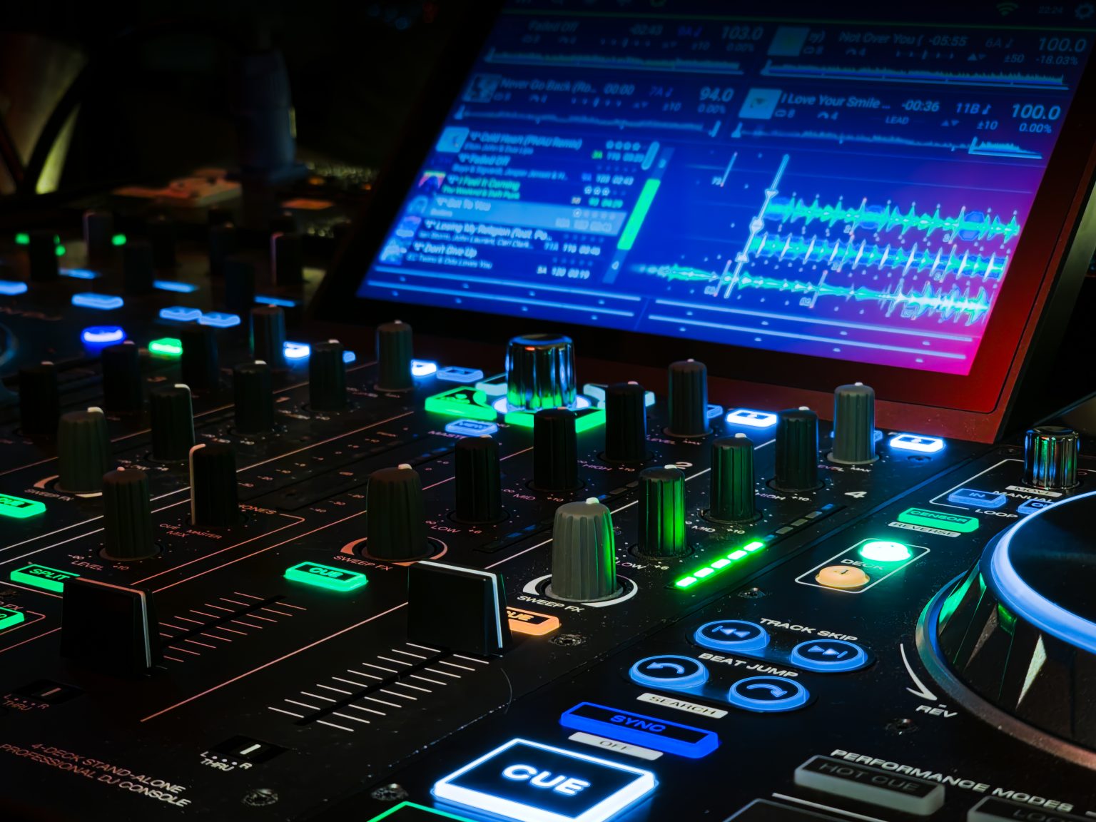 DJ-controller og mixer oplyst i farvet festlys